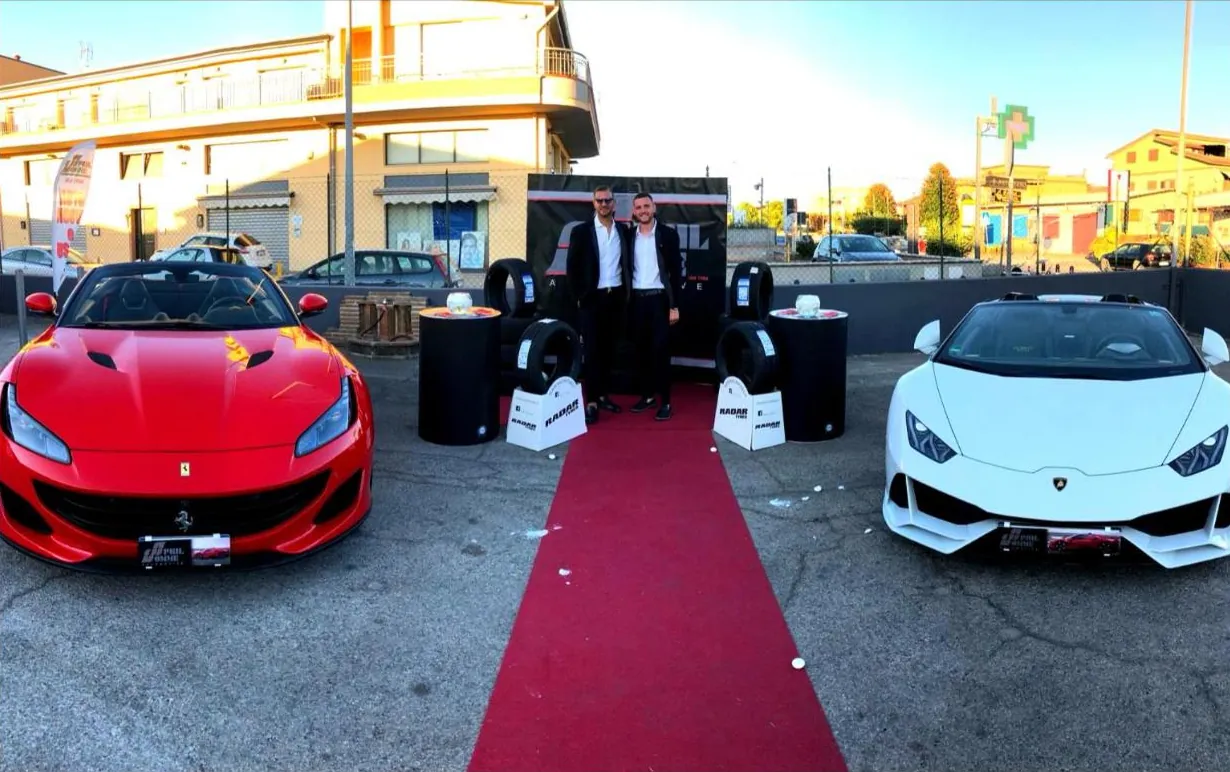 Lo staff AprilGomme sul tappeto rosso tra due supercar