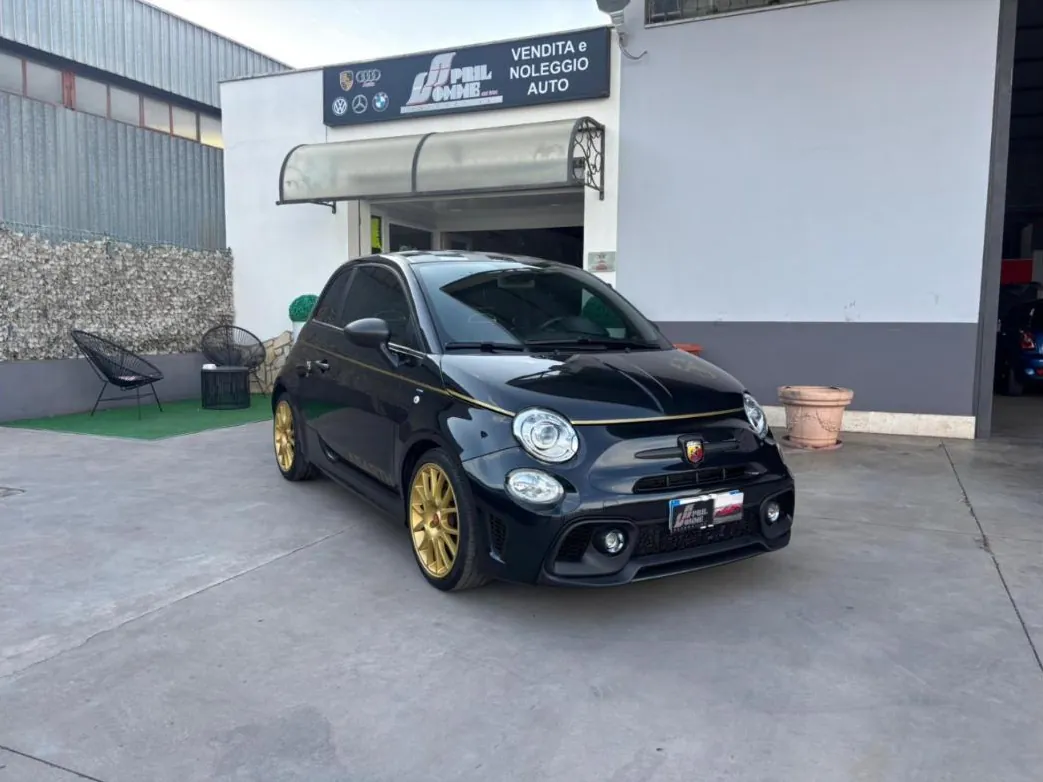 Utilitaria sportiva nera con cerchi oro davanti all'ingresso vendita e noleggio